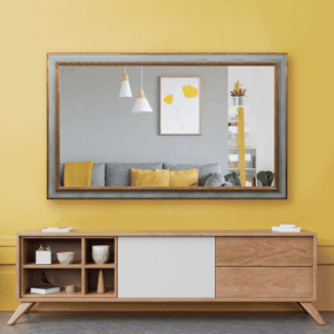 A modern wooden sideboard stands against a yellow wall with a large mirror reflecting a living room scene.