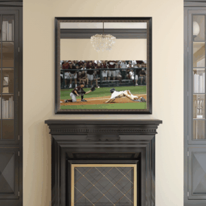 A framed mirror above a fireplace reflects a baseball game scene showing a player sliding into home plate.